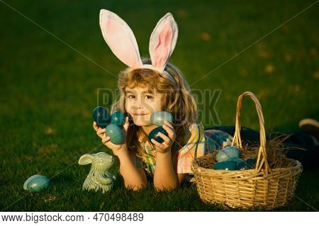 Child Boy With Easter Eggs In Basket Outdoor. Kid Laying On Grass In Park. Easter Egg Hunt. Fynny Ki