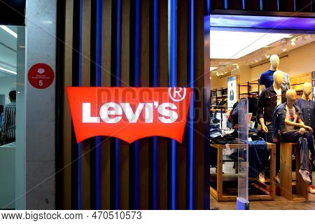 Levis Logo Outside An Outlet In A Mall. Mall Visible On The Right Side. Mannequins Visible With Clot