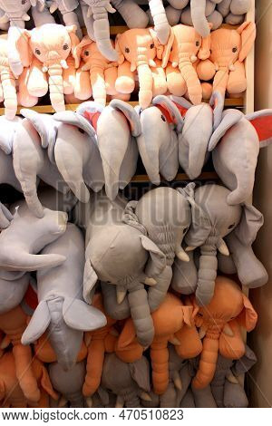 Stuffed Animals Arranged In A Shelf For Sale. Grey And Peach Colored Elephants Stuffed In A Shelf. C