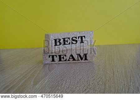 Words 'best Team' Symbol On Brick Blocks On A Wooden Table On A Beautiful Yellow Background. Busines