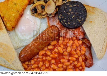 White Board With Full English Breakfast With Bacon, Fried Egg, Beans, Tomato, Roasted Sausage, Black