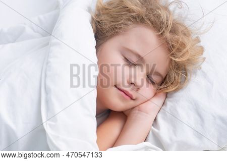 Kid Enjoying Sweet Dreams. Little Boy Sleeping In Bed. Cute Kid Sleeping Well Alone In Bed Under Bla