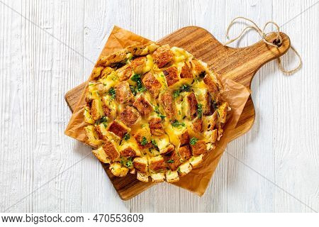 Cheesy Garlic Bread, Pull Apart Whole Round Bread On Cutting Board On White Wood Table, Horizontal V