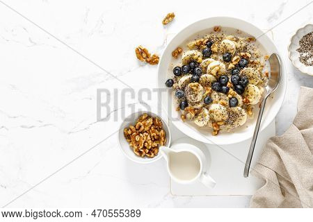 Oatmeal Bowl. Oat Porridge With Banana, Blueberry, Walnut, Chia Seeds And Oat Milk For Healthy Break