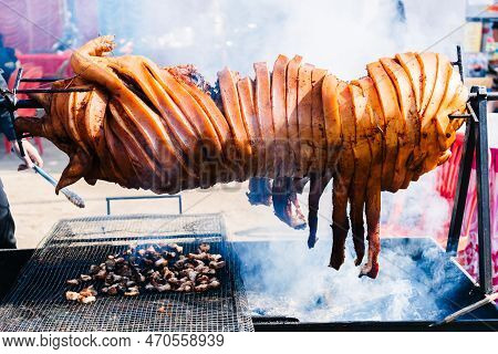 Whole Pork Barbeque On A Charcoal Grill Outdoor.