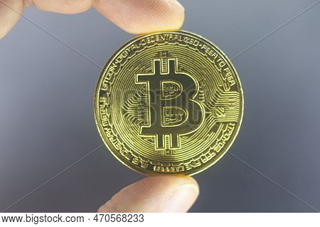 Finger Hold Bitcoin Golden On Black Isolated. Hand Hold Gold Bitcoin Crypto Ditital Money Concept. O