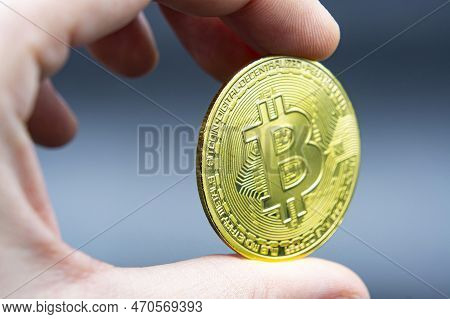 Finger Hold Bitcoin Golden On Black Isolated. Hand Hold Gold Bitcoin Crypto Ditital Money Concept. O