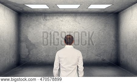 Alone Businessman Looking On Empty Concerete Wall. Business And Challenge Concept.