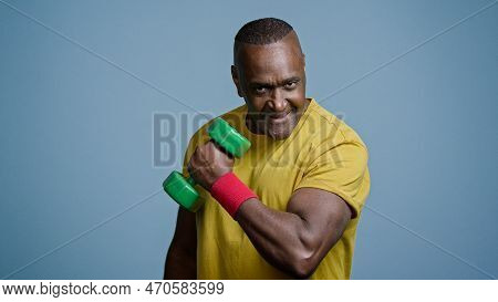 Mature Strong Athletic Man Coach Pumping Biceps With Dumbbell In Studio On Gray Background Doing Exe