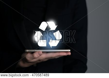 Hand Holding Recycle Symbol On A Screen Of Mobile Phone. Mobile Applications As Asource Of Informati