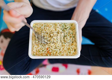 A Top View Shot Of Someone Enjoying A Quick And Unhealthy Meal Of Instant Noodles, With The Focus On