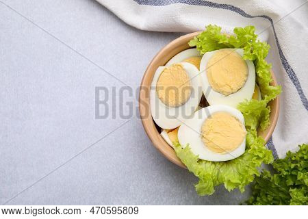 Fresh Hard Boiled Eggs And Lettuce On Light Grey Table, Top View. Space For Text