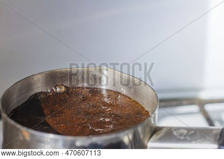 Barista Preparing Hot Tasty Drink From Copper Turk, Boils Water For Coffee On Small Fire In Cezve. C