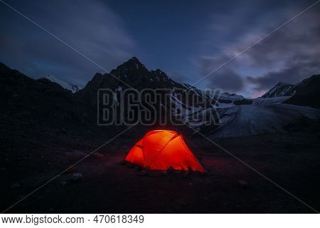 Awesome Mountain Landscape With Vivid Orange Tent Near Large Glacier Tongue Under Clouds In Night St