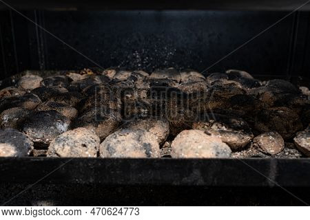 Cleaning A Dirty Grill While Standing On The Terrace And Emptying The Ashes.
