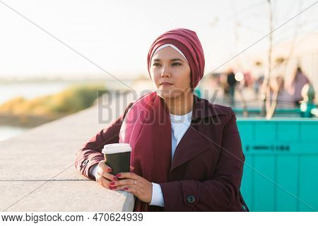 Portrait Arab Woman In Hijab Drinking Coffee In Cafe Outdoors, Copy Space And Empty Place For Advert