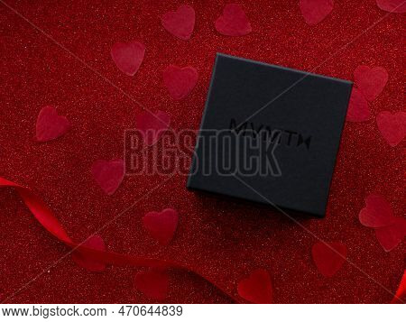 Mvmt Barend. Black Gift Box Is On Red Heart Paper Background, Top View. Greeting Card, Present. Vale