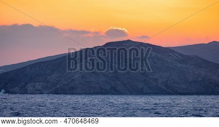Rocky Island On Mediterranean Sea. Rinia Near Mikonos, Greece, Europe. Nature Background. Sunrise Sk