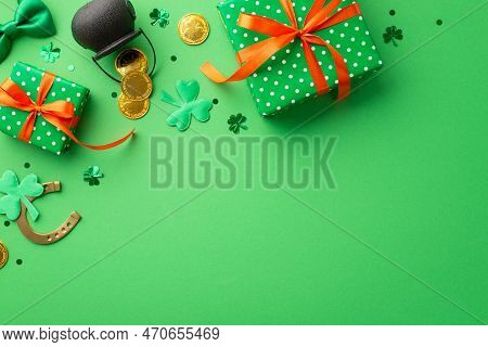 Saint Patrick's Day Concept. Top View Photo Of Green Gift Boxes With Orange Ribbon Bows Pot With Gol