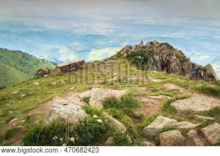 A Bench For A Halt On Mount Furmanov In Kazakhstan Mountains. View Towards Almaty City