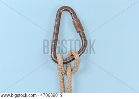 Rope Knot Munter Hitch Tied On The Old Steel Carabiner Using A Climbing Rope On A Blue Background