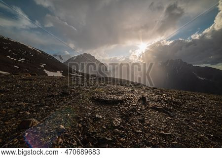 Dramatic Alpine Landscape With Sunlit Mountain With Sharp Stones With View To High Snow Mountains An