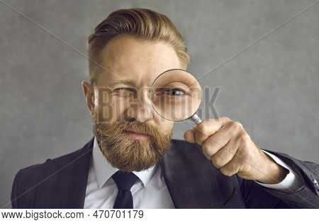 Portrait Of A Businessman In Search Of A Solution Looking Through A Magnifying Glass