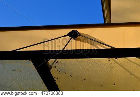 Glass Shelter By A Beige Historical Building. Attached To The Facade Of The Wall In A Metal Frame Su