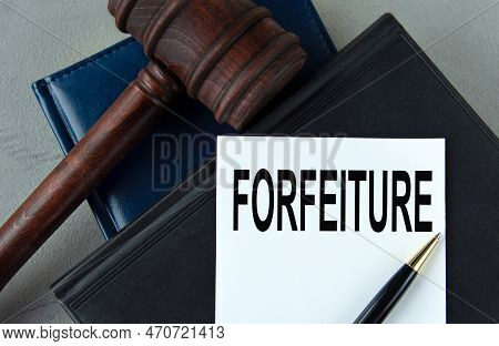 Forfeiture - Word On A White Sheet With Leather Notebooks, A Judge's Hammer And A Pen