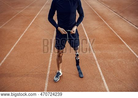 A Runner With Prosthetic Leg Preparing For Workout On Running Track At Stadium.