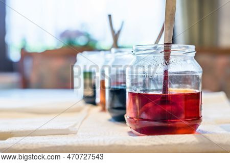 Easter Eggs Color At Home In The Kitchen With Cucumber Glasses And Various Colors, Germany