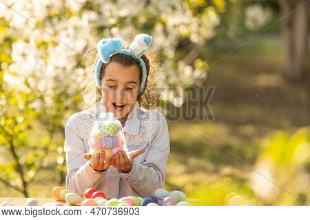 Teenage Girl Paints Easter Eggs In The Garden.