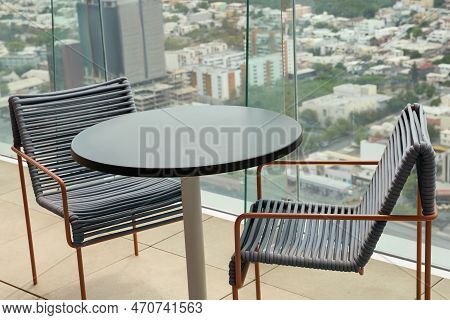 Coffee Table And Chairs Against Picturesque Landscape Of City In Cafe