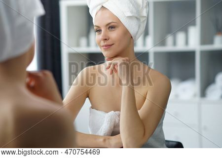 Young Woman Sits In The Bathroom In Front Of The Makeup Mirror And Does Cosmetic Procedures. Beautif