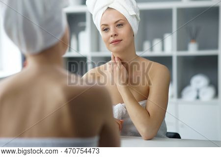 Young Woman Sits In The Bathroom In Front Of The Makeup Mirror And Does Cosmetic Procedures. Beautif
