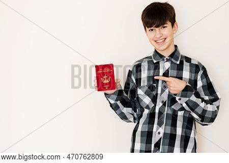 Young Teenager Boy Holding Brunei Passport Looking Positive And Happy Standing And Smiling With A Co