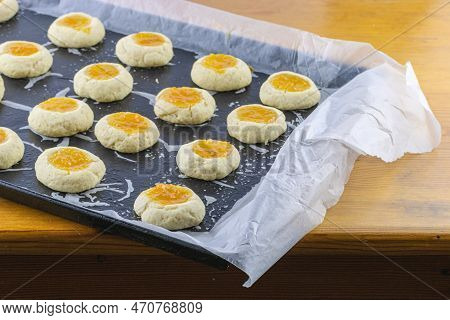 Half-cooked Thumb Print Cookies Filled With Apricot Jam On Baking Sheet. Selecive Focus With Copy Sp