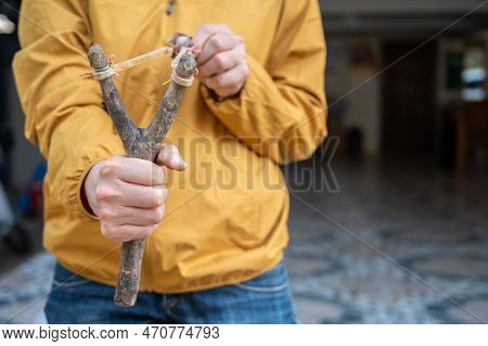 Someone Using A Wood Slingshot For Shooting Somethings. And A Slingshot Works Like A Small Catapult,