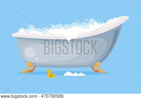 Cast Iron Bathtub On Claw Foot Pedestal Full Of Water With Soap Bubbles Foam Isolated On Blue Backgr