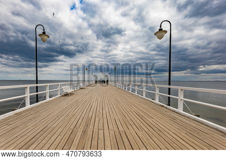 Gdynia, Poland - April 2022: Beautiful Long Wooden Pier With Lamps On Both Sides And Walking People