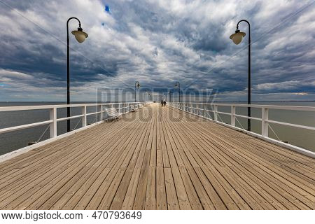 Gdynia, Poland - April 2022: Beautiful Long Wooden Pier With Lamps On Both Sides And Walking People