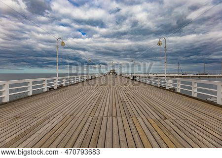 Sopot, Poland - April 2022: Beautiful Long Wooden Pier With Lamps On Both Sides And Walking People