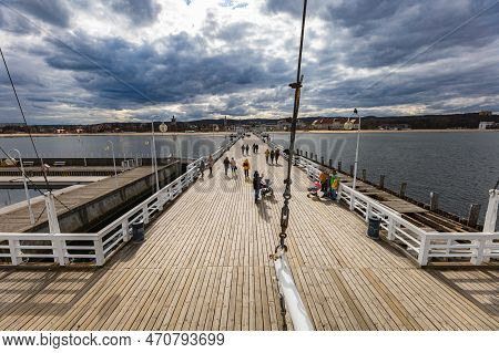Sopot, Poland - April 2022: Beautiful Long Wooden Pier With Lamps On Both Sides And Walking People