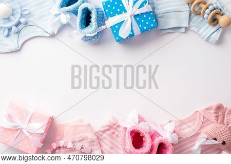 Gender Reveal Party Concept. Top View Photo Of Pink And Blue Infant Clothes Shirts Pants Knitted Boo