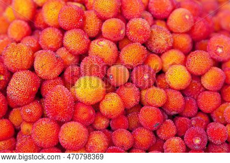 Close-up On A Stack Of Arbutus Berries For Sale On A Market Stall.