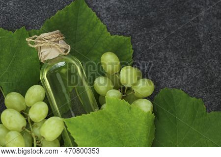Grape Oil.grape Vinegar.oil In A Bottle And Grapes With Leaves On A Gray Slate Background.organic Oi