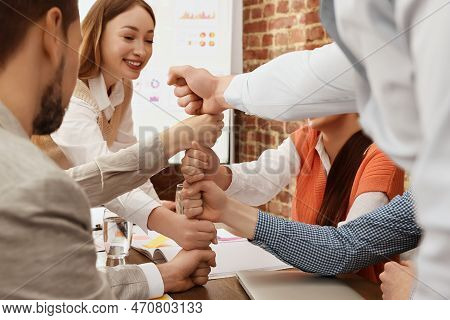 Office Employees Joining Hands During Meeting At Work