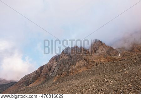 Scenic Alpine Landscape With Rocky Mountains In Dense Low Clouds In Morning Sunlight. Colorful Mount
