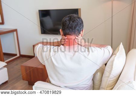 Man Having Neck And Shoulder Pain During Sitting On Sofa. Due To Fibromyalgia, Rheumatism, Scapular 