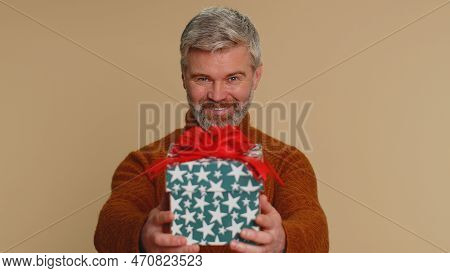 Positive Smiling Middle-aged Man Presenting Birthday Gift Box Stretches Out Hands, Offer Wrapped Pre